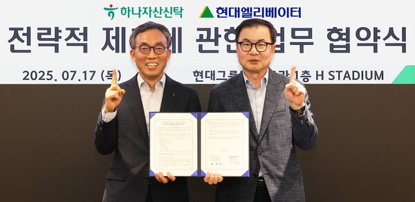 민관식 하나자산신탁 대표(왼쪽)와 조재철 현대엘리베이터 대표가 오피스자산 밸류애드(Value-add) 전략 가속화를 위한 업무협약을 체결한후 함께 협약서를 들어보이고 있다. (사진=하나자산신탁)