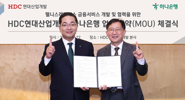 이호성 하나은행장(왼쪽)과 정경구 HDC현대산업개발 대표가 웰니스 레지던스 사업 활성화 및 입주자 맞춤형 종합자산관리 서비스 제공을 위한 업무협약을 체결한후 함께 협약서를 들어보이고 있다. (사진=하나은행)