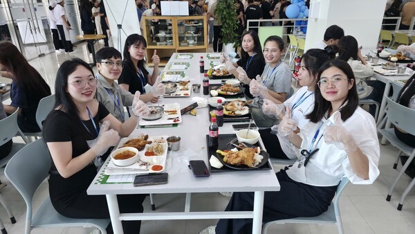 삼성 베트남법인의 현지인 근로자들이 aT와 삼성웰스토리의 한국산 닭고기를 활용한 ‘K-급식 체험 홍보 행사’에서 줄지어 배식을 받아 식사를 하려하고 있다. (사진=한국농수산식품유통공사)