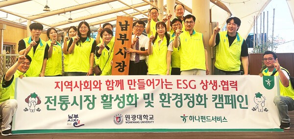 하나펀드서비스 임직원들이 전북 익산시 남부시장에서 환경정화 봉사활동을 시작에 앞서 기념촬영을 하고 있다. (사진=하나펀드서비스)