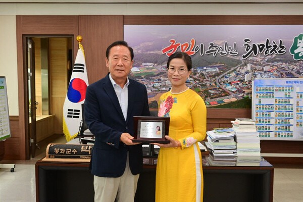 베트남 출신의 도 옥 루이엔 광운대 교수(오른쪽)가 경북 봉화군청에서 열린 홍보대사 위촉식에서 박현국 봉화군수와 함께 위촉패를 들고 기념촬영을 하고 있다. 한국학•한국문화 전문가인 루이엔 교수는 앞으로 2년간 봉화군 홍보, 베트남 이주민 유치및 정착지원 등 다양한 활동을 펼칠 예정이다. (사진=봉화군)