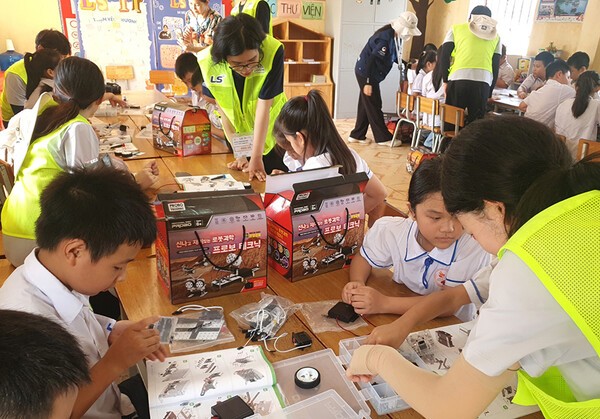 LS 대학생해외봉사단원들이 베트남 하이퐁 팜타이 초등학교에서 학생들을 대상으로 과학키트 만들기 체험학습을 진행하고 있다. (사진=LS)