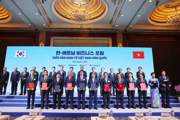 김민석 총리아 또 럼 베트남 서기장(뒷줄 중앙 좌우)이 한-베트남 비즈니스 포럼에서 양해각서를 체결한 양국 기업•기관 대표들과 기념촬영을 하고 있다. (사진=국무조정실)