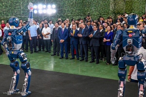 하노이 국가전시센터에서 빈그룹이 개발한 휴머노이드 로봇의 움직임을 살펴보고 있는 또 럼 베트남 공산당 서기장과 팜 민 찐 총리 등 베트남 지도부의 모습. 베트남이 8월 혁명일 80주년을 기념해 전국에서 대규모 착·준공식을 개최했다. (사진=VnExpress/Giang Huy)