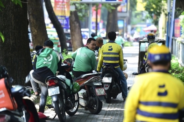 베트남 호출플랫폼 오토바이 택시기사들이 그늘에서 휴식을 취하며 대기하고 있다. 호치민시가 영업용 이륜차 100% 전동화 계획을 밝힌 가운데 충분한 충전망 구축과 재정 지원이 최대 과제로 떠올랐다. (사진=VnExpress/Thanh Tung)