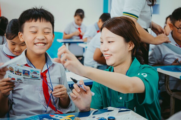 하노이 뜨끄엉 초등학교 학생이 미술교육 봉사활동에 나선 하나금융그룹 홍보대사의 도움에 활짝 웃으며 즐겁게 수업하고 있다. (사진=하나금융그룹)
