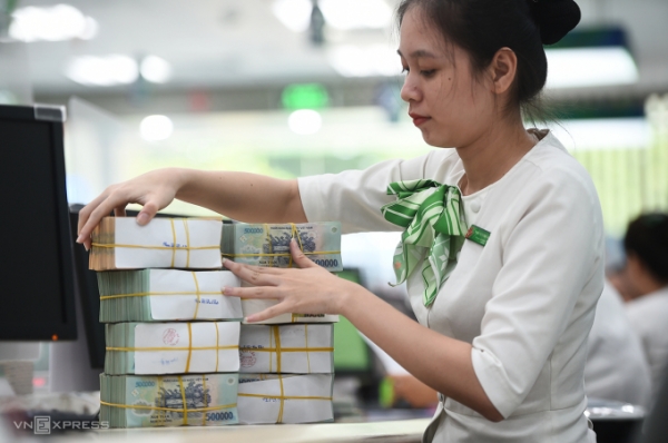베트남 한 은행에서 행원이 현금을 정리중인 모습. 베트남이 현행 7단계인 개인소득세 누진체계를 5단계로 개편할 계획이다. 다만 35%인 최고 세율은 현재와 동일하게 유지될 전망이다. (사진=VnExpress/Thanh Tung)