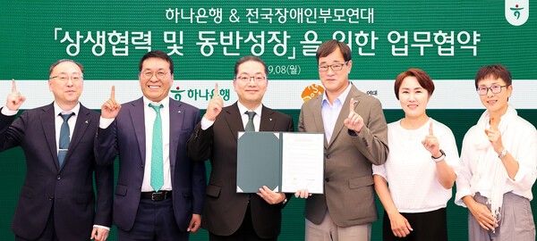 이호성 하나은행장과 윤종술 전국장애인부모연대 회장이 상생협력 업무협약을 체결한후 함께 협약서를 들고 양측 임원들과 기념촬영을 하고 있다. (왼쪽에서부터) 하나은행 이정현 강남영업본부 지역대표, 김진우 중앙영업그룹 부행장, 이호성 은행장, 전국장애인부모연대 윤종술 회장, 김남연 부회장, 김종욱 이사.(사진=하나금융)