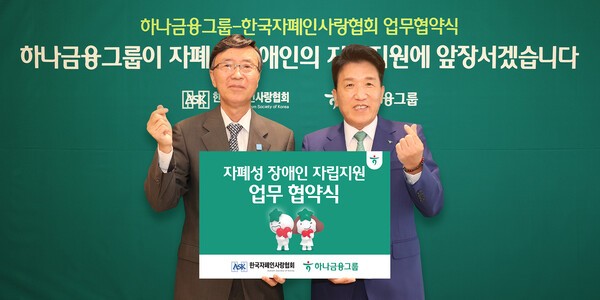 함영주 하나금융그룹 회장(오른쪽)과 김용직 한국자폐인사랑협회 회장과 자폐성 장애인의 안정적 사회정착 및 자립기반 확립 지원 업무협약을 체결한후 함께 협약서 패널을 패널을 들어보이고 있다. (사진=하나금융그룹)