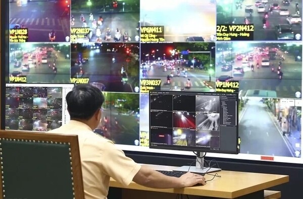 베트남에서 교통법규 위반으로 적발된 운전자에게 위반 사실 고지전 AI 카메라를 통해 제공된 이미지를 재확인 중인 교통경찰의 모습. (사진=VnExpress/Viet An)
