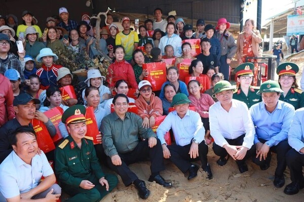 팜 민 찐 베트남 총리(앞줄 왼쪽 세번째)와 데기 지역 주민들이 단체 사진을 촬영 중인 모습. 이날 태풍 갈매기 피해 현장을 방문한 찐 총리는 주택 수리와 양식업 시설 복구 지원 등 지역민들이 조속한 일상으로 복귀할 수 있도록 정부 차원의 지원을 약속했다. (사진=VnExpress/Ngoc Oanh)