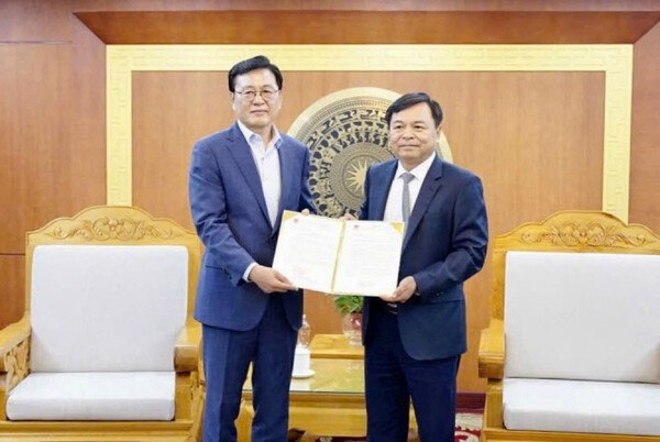 이충연 에스텍시스템 경영지원실장이 베트남 농업환경부 응웬 호앙 히엡 차관에게 중부지역 홍수피해 복구 성금을 전달한위 함께 성금기부 패널을 들어보이고 있다. (사진=에스텍시스템)